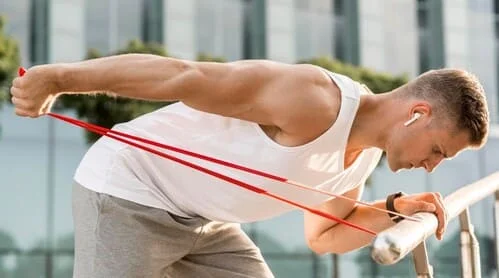 Un homme qui pratique un exercice de renforcement musculaire avec une bande de résistance.