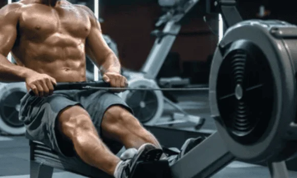 Homme sportif qui s'entraine pour du renforcement musculaire sur rameur indoor.