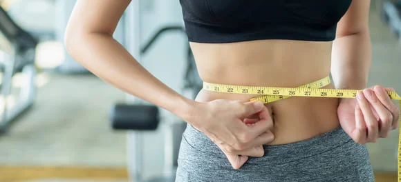 Femme sportive qui a brulé des calories après des séances de cardio sur rameur indoor.